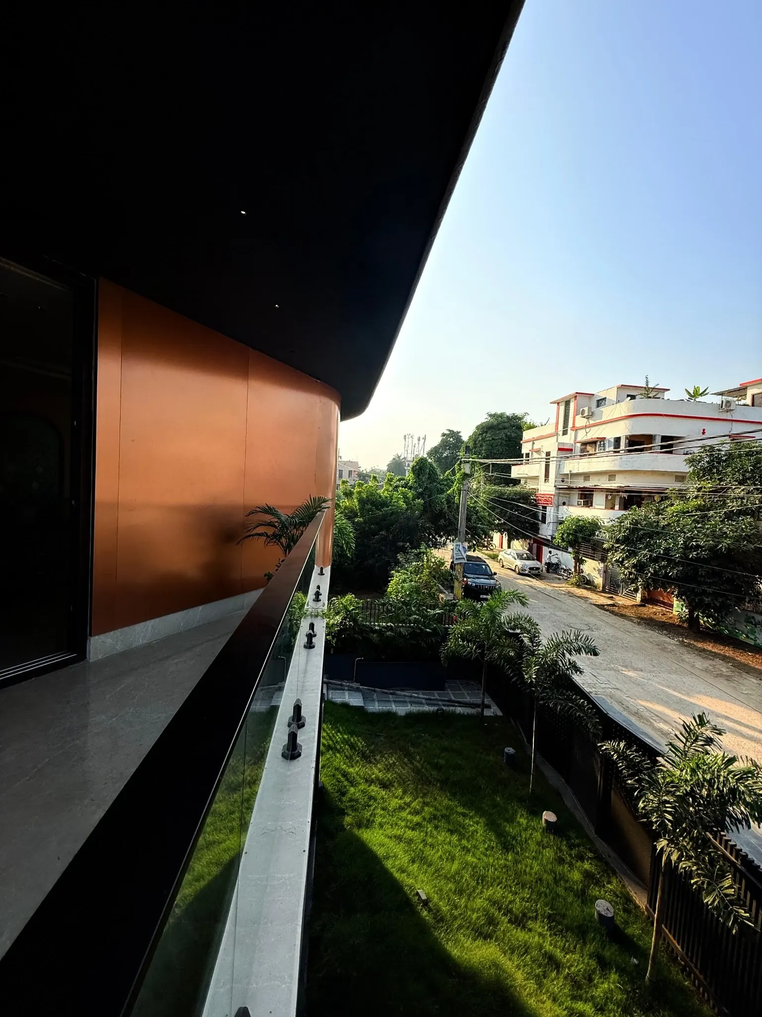 View from a shaded Unnati balcony over the garden and neighbouring street