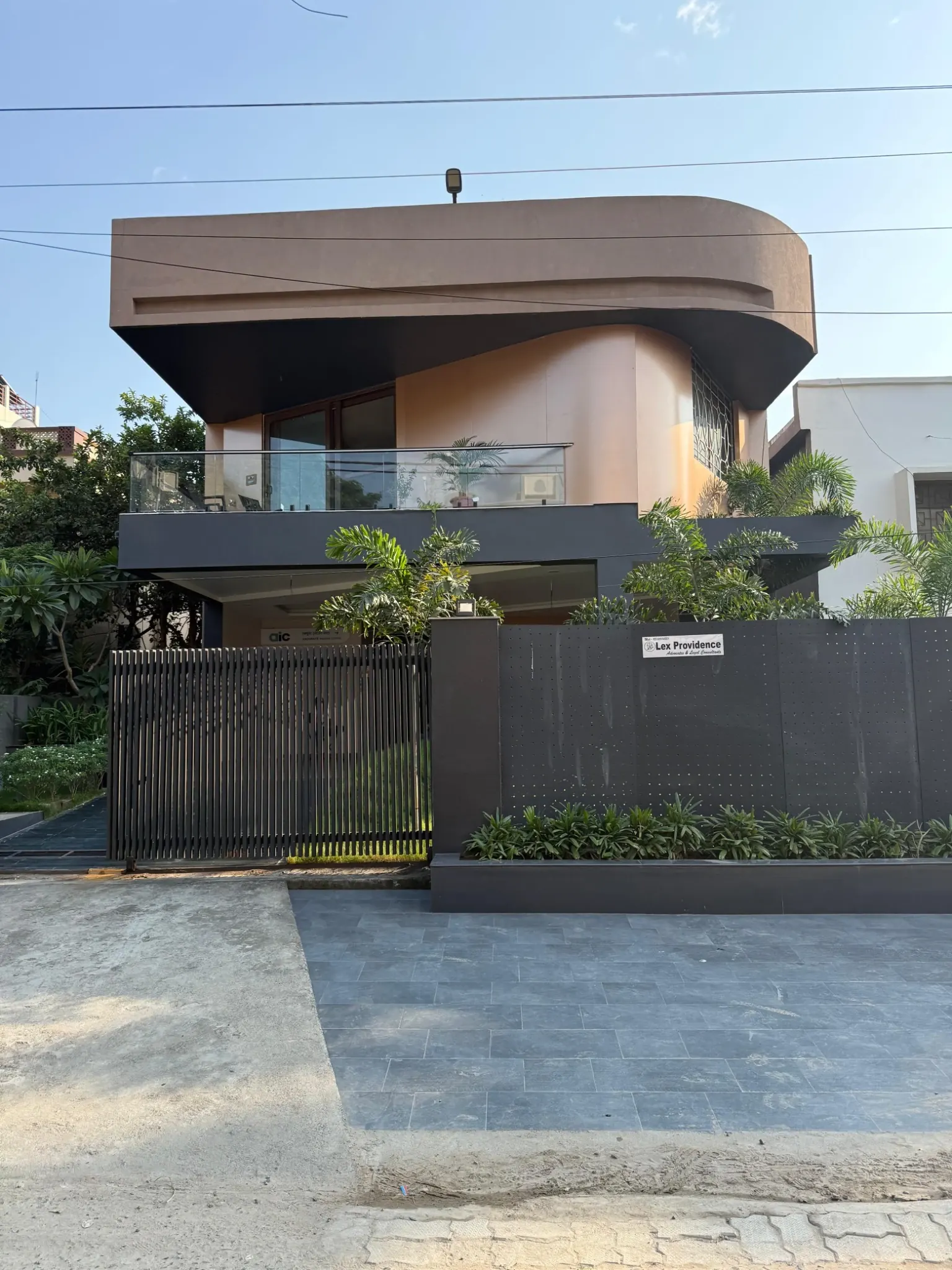 Front photograph of Unnati with a rounded upper volume, palms and a dark gate