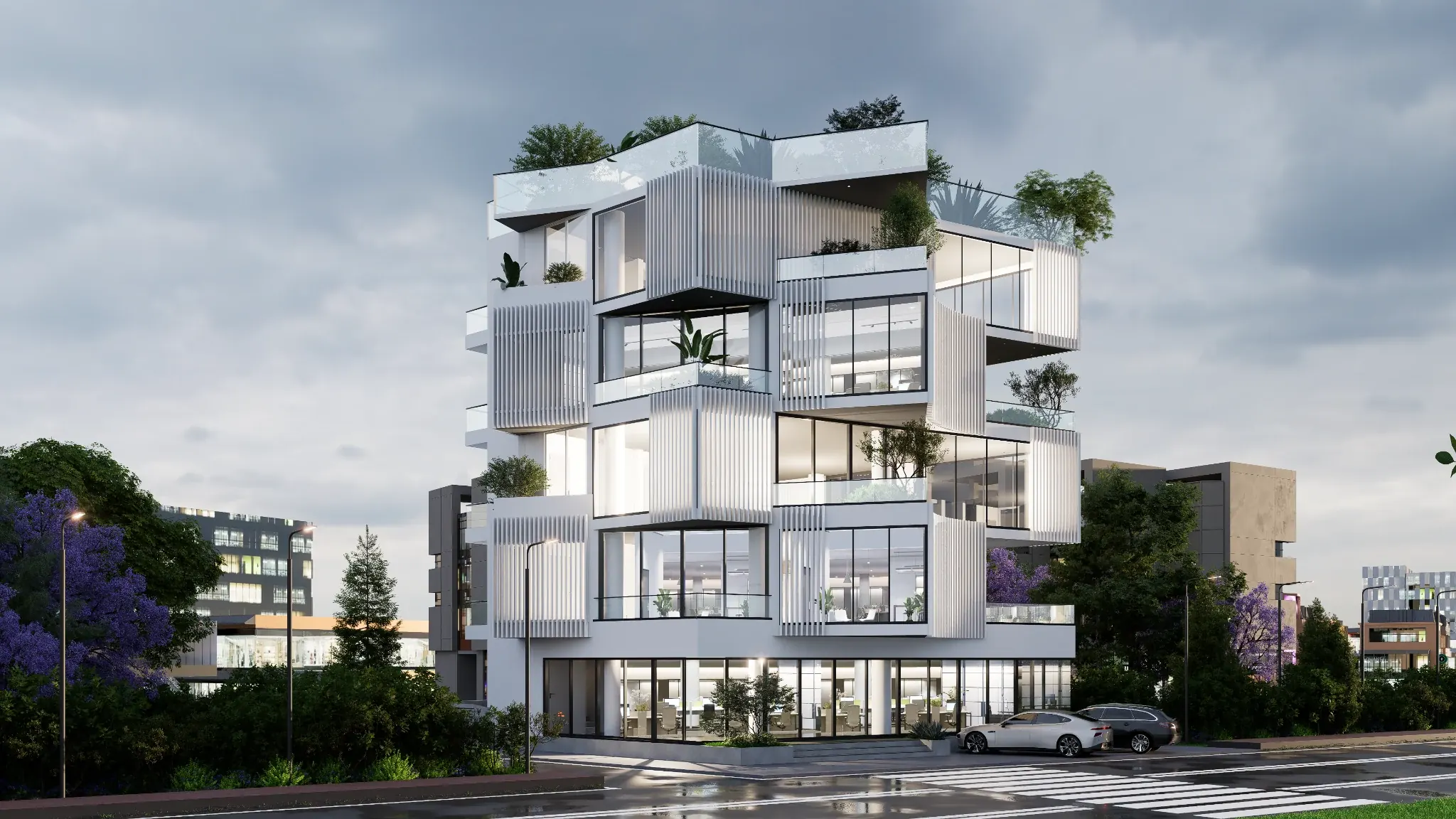 Evening architectural study of the white facade, glass storefront and layered balconies